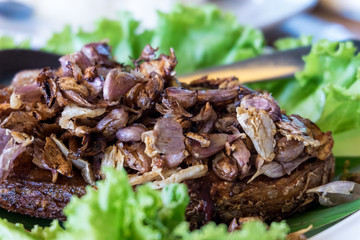 Fried fish topped with garlic served on white dish