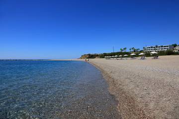 Piękna kamienista plaża wzdłuż błękitnego morza.