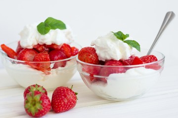 Glass bowl of strawberries with whipped cream. Traditional snack at famous lawn tennis tournament.