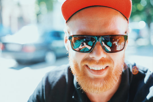 Beautiful man in sunglasses. Smartphone reflection
