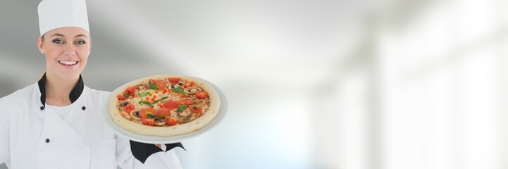 Chef holding pizza with blurred background