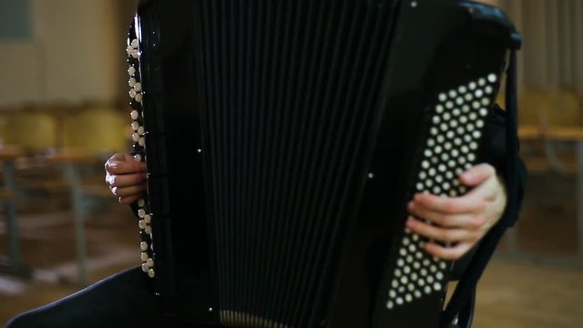 The face of the accordionist. Fingers of accordionist on the keys