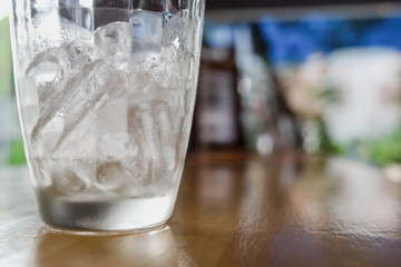 Glass with ice on table