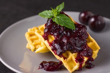 Waffles with cherry jam and mint leaves