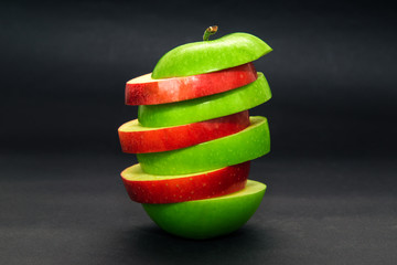 Fototapeta na wymiar Red and green apple cut dark background