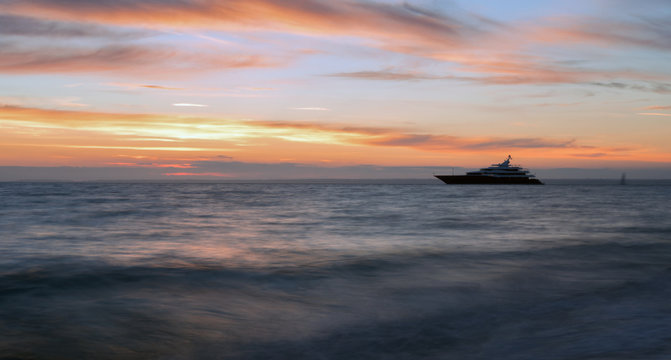 Luxury 'Super Yacht' moored up against a romantic vibrant sunset