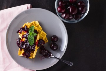 Top view of waffles with (sour) cherry preserve and mint leaves