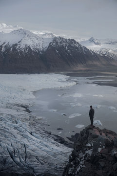 Man standing on rock by lake