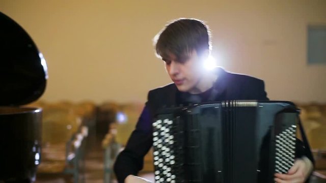 The face of the accordionist. Fingers of accordionist on the keys