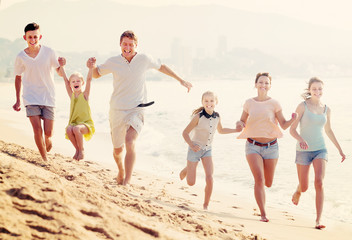 Family happily running together on beach