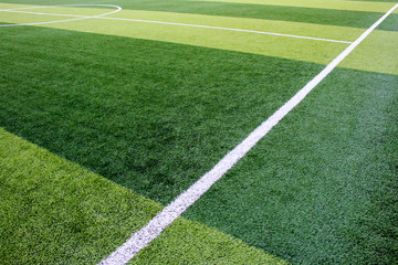 Fototapeta na wymiar The white Line marking on the artificial green grass soccer field