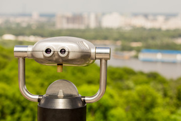 Stationary observation binoculars , metropolis landscape on the background with bridge, river,...