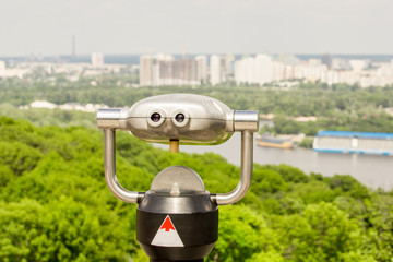 Stationary observation binoculars , metropolis landscape on the background with bridge, river,...