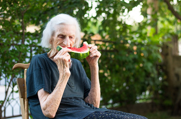 Senior woman eating watermelon outdoors