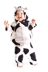 A baby in a fancy dress cow costume on a white background