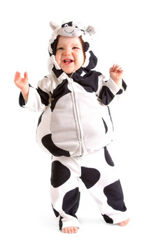 A Baby In A Fancy Dress Cow Costume On A White Background