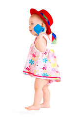 Lovely baby in colored dress and red hat are playing on a white background