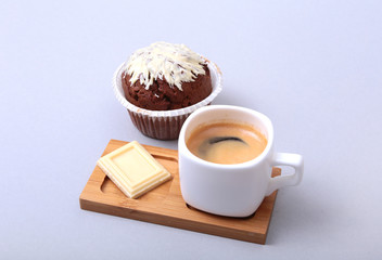Classic espresso in white cup with homemade cake and chocolate on white background.