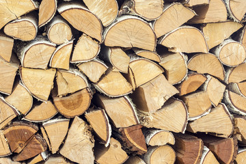 Natural wooden background, closeup of chopped firewood, logs.  Chopped firewood on a stack