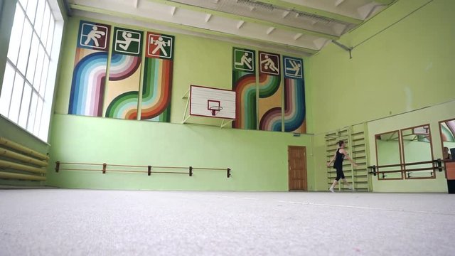 The girl makes a gymnastic jump in the gym