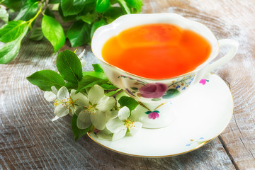 Tea cup on wooden table and apple blossom
