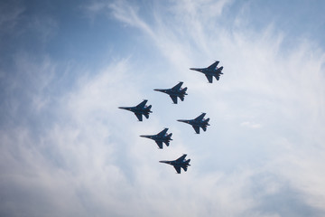 Fototapeta na wymiar Team of pilots russian knights do comlex aerobatic figure on su-27 and mig-29 in the sky