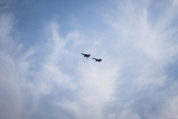 Group of two pilots make aerobatics figure on su-27 fighter in the sky at air show