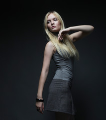 Portrait of beautiful young blonde girl in black dress. 