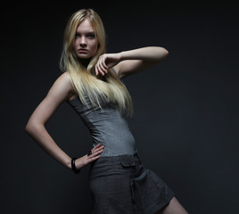 Fototapeta premium Portrait of beautiful young blonde girl in black dress. 