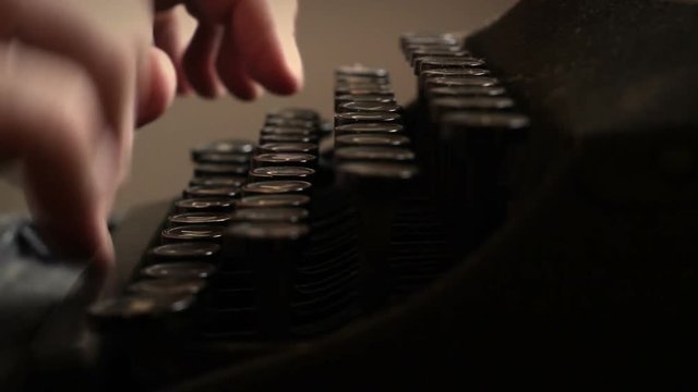 Typing on an old typewriter in a dark journalism newspaper office - Angle 2