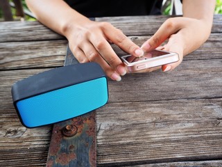 Woman using bluetooth speaker with smart phone