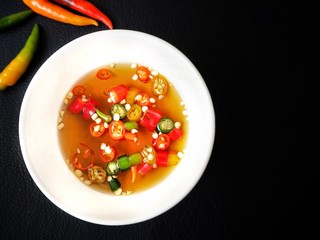 Fish sauce with chili on black background