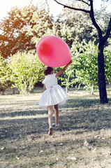 pretty girl runing jumping and holding big balloon
