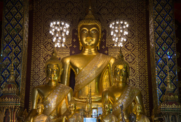 Fototapeta premium The Buddha statue in viharn of Wat Phra That Hariphunchai the iconic famous temple in Lamphun city, Northern Thailand.