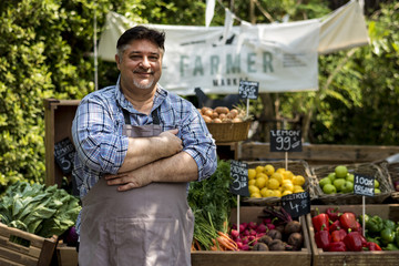 Greengrocer selling organic fresh agricultural product at farmer market