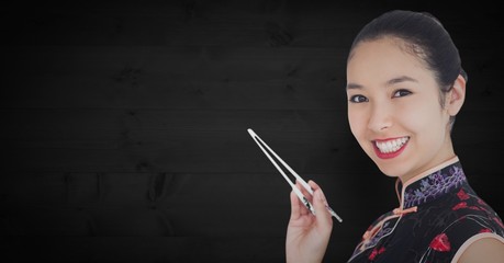 Close up of geisha with chopsticks against dark wood panel