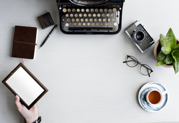 Retro Typewriter with Hand Holding Photo Wooden Frame on Gray Table - obrazy, fototapety, plakaty