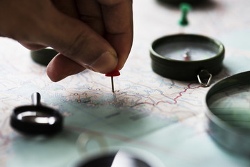 Fototapeta na wymiar Closeup of hand pinning on world map journey travel