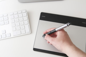 hand using a pen tablet on the desk