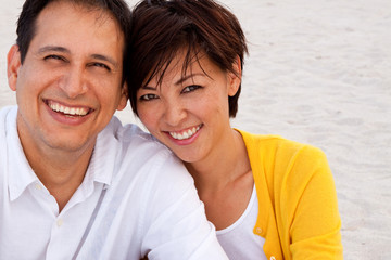 Obraz premium Happy couple laughing and talking at the beach.
