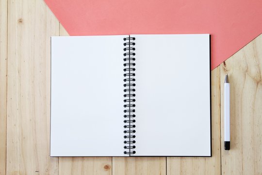 Still life, business, office supplies or education concept : Top view image of open notebook with blank pages and pen on wooden background, ready for adding or mock up