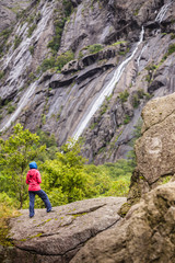 Fototapeta premium Woman on mountain rock enjoying beautiful view