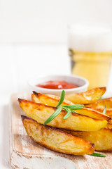 Baked fried potatoes with red sauce and beer, selective focus