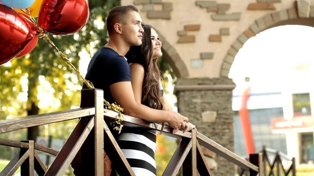 Young couple in love with balloons spending time together in a recreation park