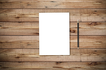 Modern workplace with blank paper and pencil copy space on wood background. Top view. Flat lay style.