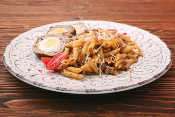 Boiled eggs in a layer of sausage meat wrapped with pasta