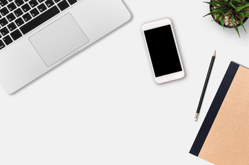 Modern workplace with notebook, smartphone, blank paper, pencil and little tree copy space on gray background. Top view. Flat lay style.