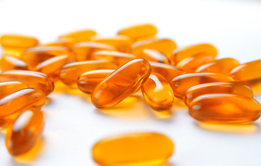 close up to pile of Fish oil capsules on a white background. soft gels capsules