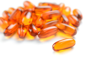 close up to pile of Fish oil capsules on a white background. soft gels capsules