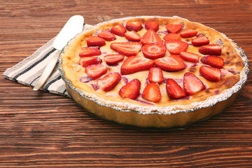 Tart with fresh strawberry on wooden background
